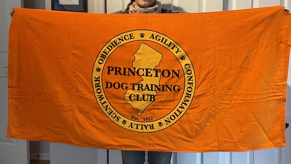 Customer photo from Andrea of our Luxury Beach Towel - Colors - 30" x 60", a person holding an orange flag