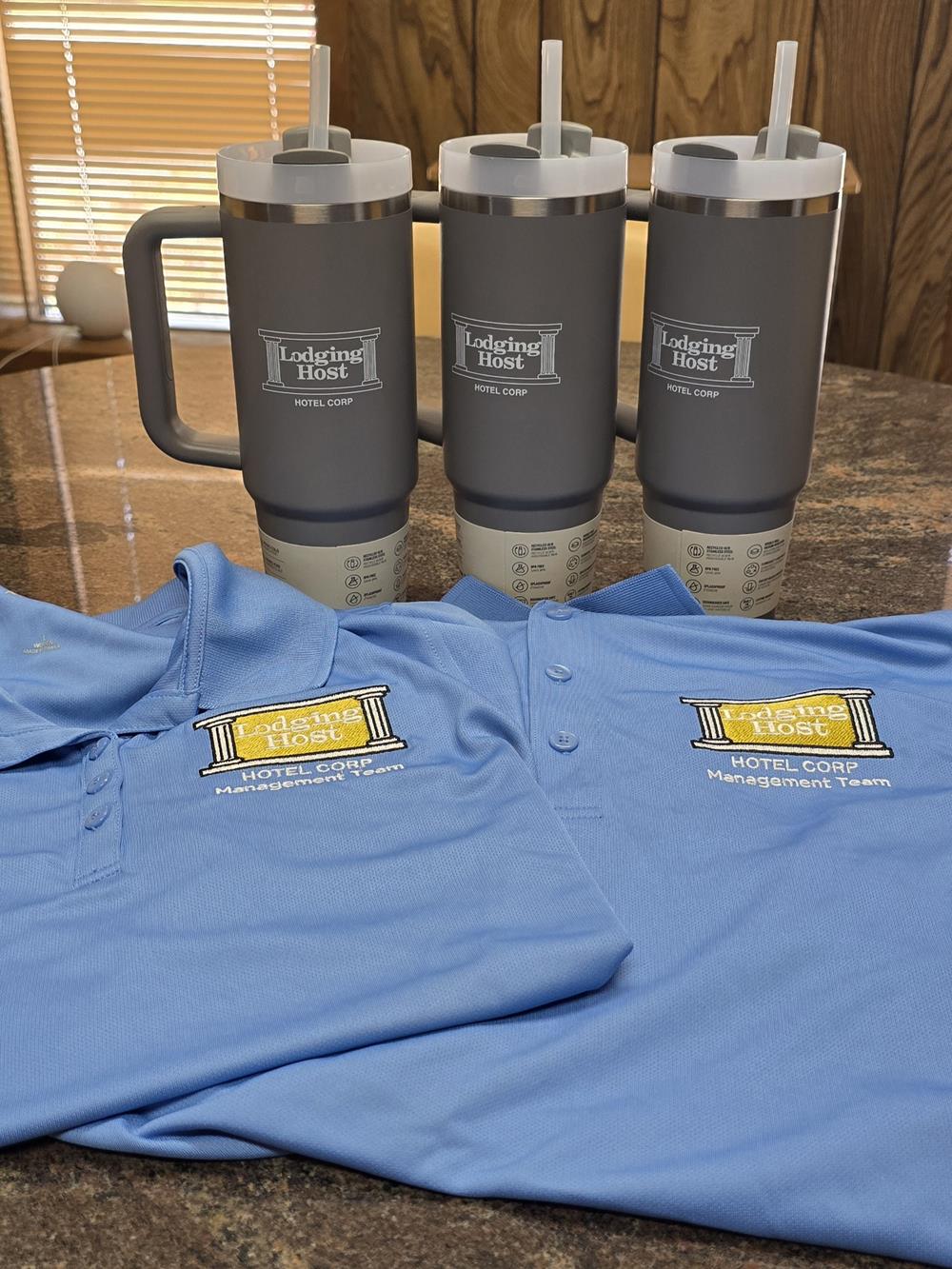Customer photo from Charisse of our Stanley Quencher H2.0 FlowState Vacuum Mug with Straw - 30 oz., a group of grey and black shirts and a mug with logos on it