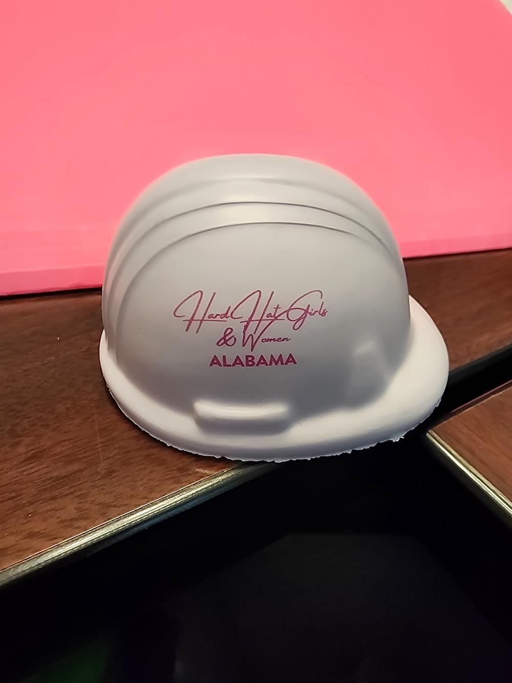 Customer photo from Nancy of our Hard Hat Stress Reliever, a white hard hat on a wood surface