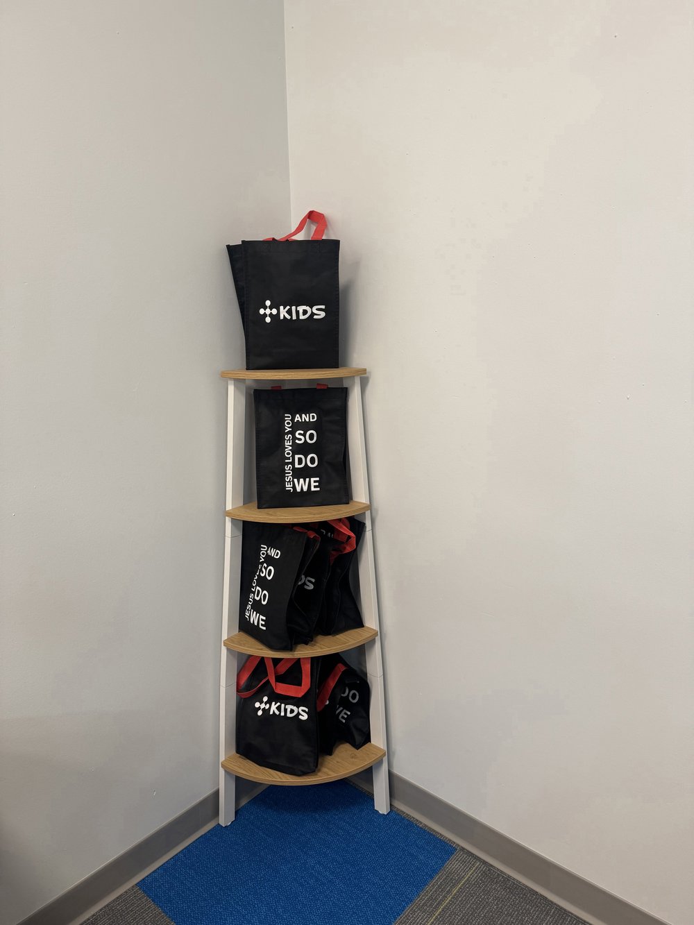 Customer photo from Jennifer of our Colored Handle Tote - 12 inches x 9 1/2 inches, a shelf with black bags on it