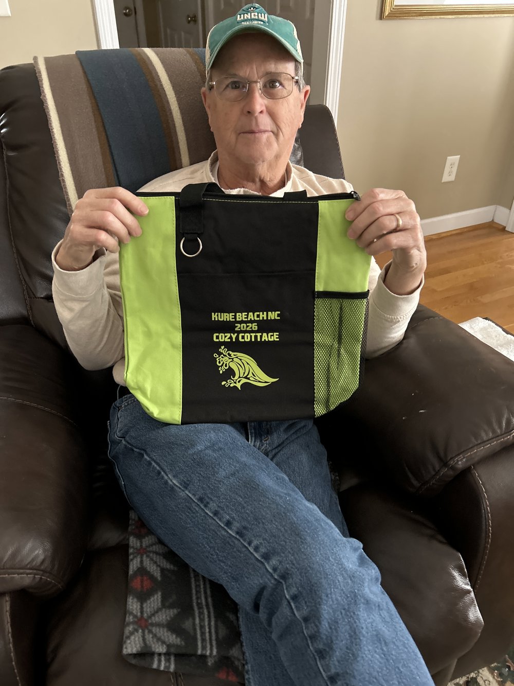 Customer photo from Ginger of our Fun Tote, a man sitting in a chair holding a bag