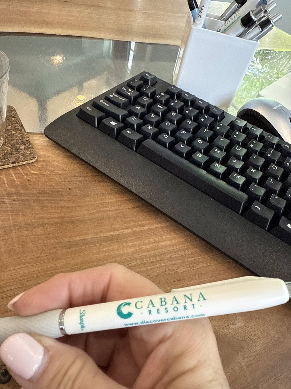Customer photo from Sandy of our Sharpie S-Gel Pen, a hand holding a pen next to a keyboard