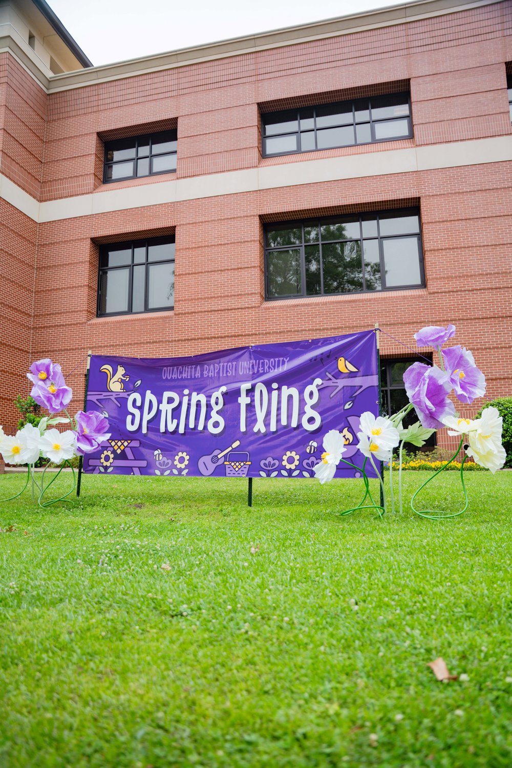 Customer photo from Ashley of our Value Outdoor Banner - 4' x 10', a purple banner with white flowers in front of a building