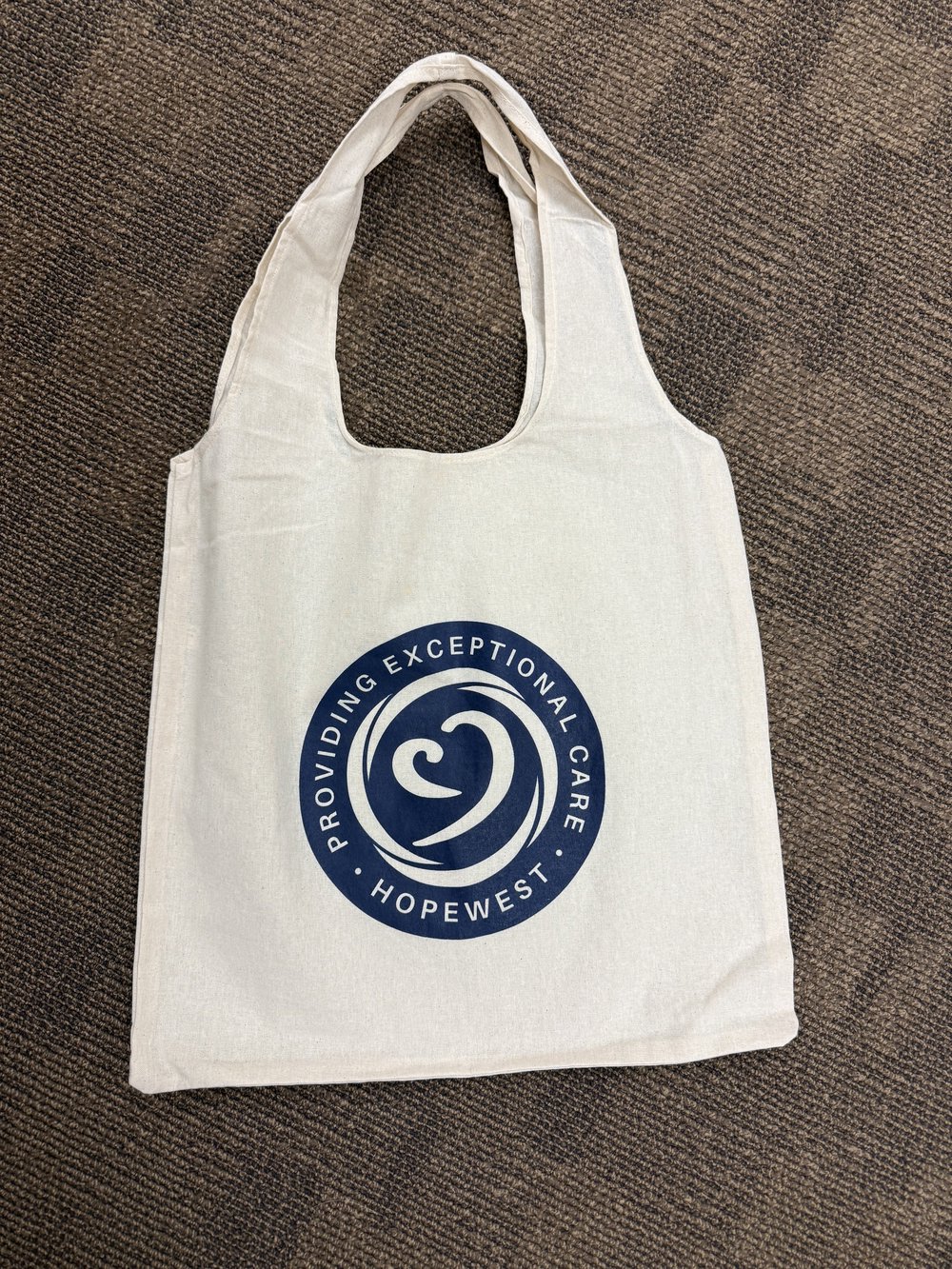 Customer photo from Jenny of our Take Home 5-oz Cotton Shopper Tote - 24 hr, a white bag with a blue circle on it