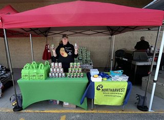 Customer photo from Jennifer of our Lunch Sack Tote, a woman standing behind a table with food items