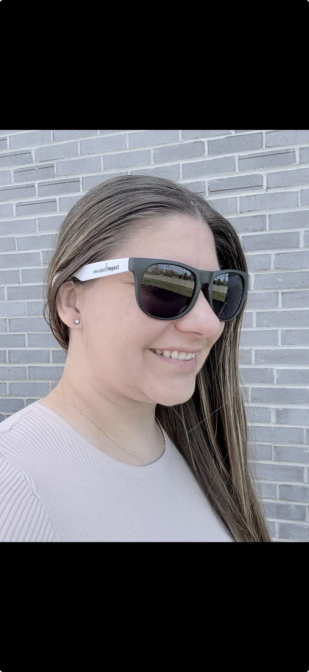 Customer photo from Jenna of our Sunglasses - 24 hr, a woman wearing sunglasses and smiling