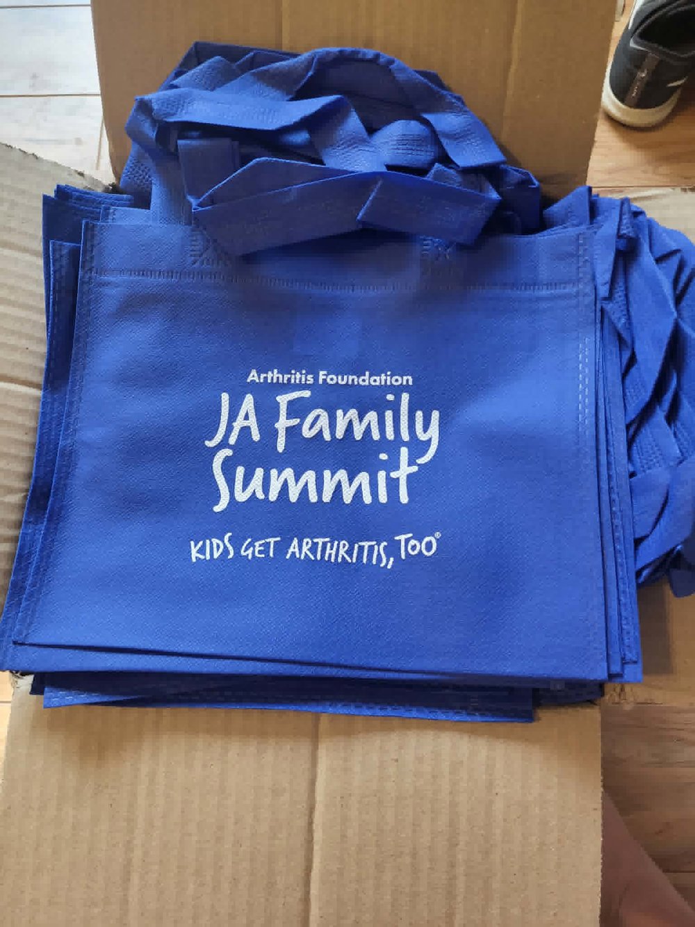 Customer photo from Tamara of our Mini Non-Woven Flat Tote, a pile of blue bags
