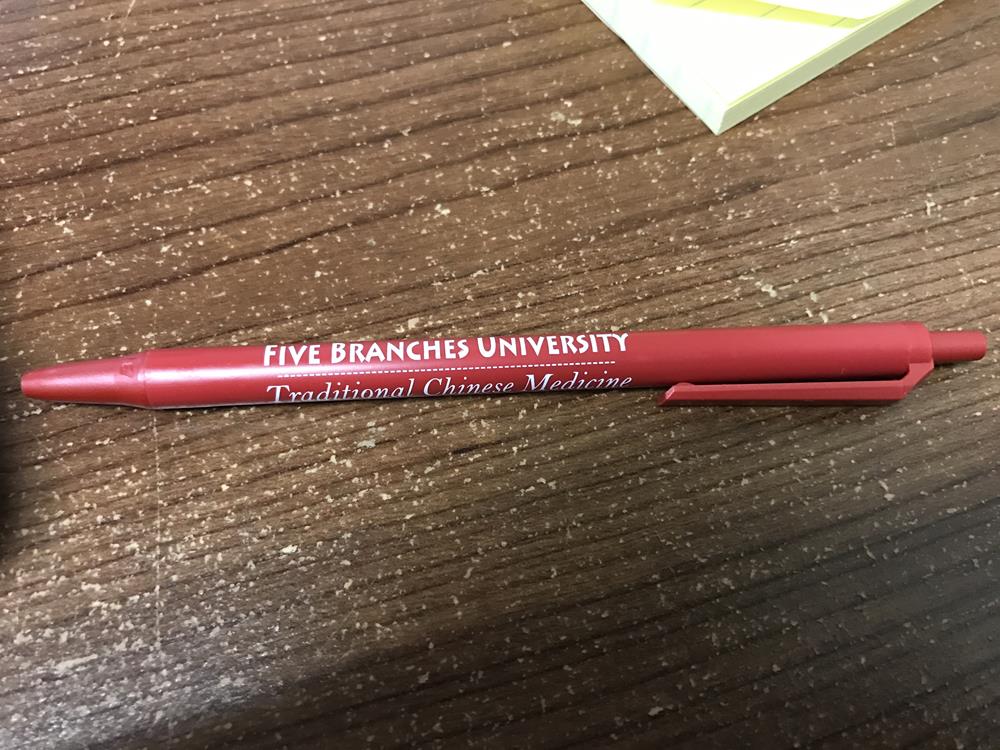 a red pen on a wood surface