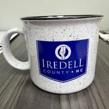 a white mug with a blue and white logo on it