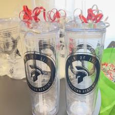 a couple of clear plastic cups with red ribbons
