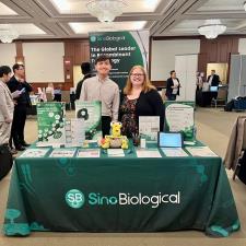 a man and woman standing next to a table with a green tablecloth