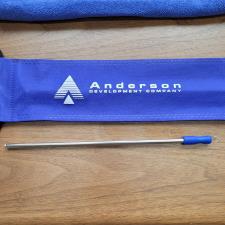 a blue bag with a silver tip next to a blue towel