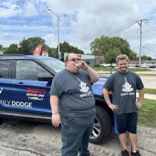 two men standing next to a car