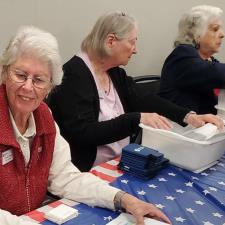 a woman sitting at a table with a flag on it