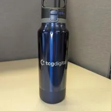 a blue water bottle on a white surface