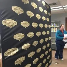 Customer photo from Brianna of our EuroFit Modular Straight Wall - 7-1/2' x 8', a woman standing next to a wall of books