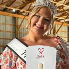 Customer photo from Kenneth of our Hand Fan - Slice, a woman wearing a crown and sash holding a fan