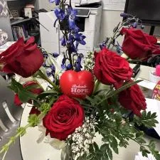 Customer photo from Carol of our Heart Stress Reliever, a bouquet of red roses and blue flowers in a glass vase