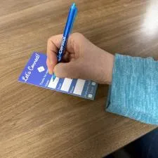 Customer photo from Tammie of our Value Click Pen - Translucent, a person holding a pen and writing on a piece of paper