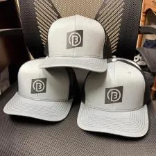 Customer photo from Ian of our Crofton Snapback Trucker Cap, a group of hats on a chair