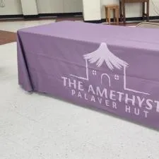 Customer photo from Grace of our Laser Edge Open-Back Table Throw - 8' - Full Color, a table with a purple cover