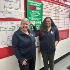 Customer photo from Eileen of our Reebok Freestyle Tech Fleece Jacket - Men's, two women standing next to a sign