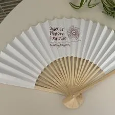 Customer photo from Charlotte of our Folding Hand Fan, a white fan on a table