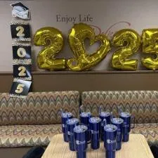 Customer photo from Vanessa of our Koozie® Big Vacuum Mug with Straw - 40 oz. - 24 hr, a table with blue cups and gold balloons on the wall