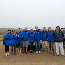Customer photo from Michael of our Fleet Performance Pro LS  Hooded T-Shirt, a group of people in blue jackets standing in front of a car