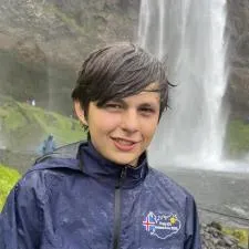 Customer photo from Kim of our Traverse Waterproof Jacket - Ladies' - Embroidered, a boy standing in front of a waterfall