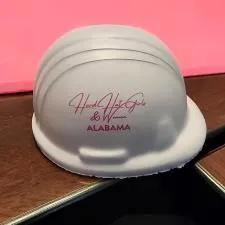 Customer photo from Nancy of our Hard Hat Stress Reliever, a white hard hat on a wood surface