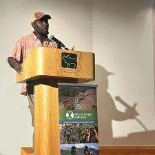 Customer photo from Katy of our Phoenix Retractable Tabletop Banner Display - 17", a man standing at a podium