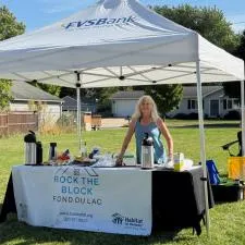 Customer photo from Kathy of our Value Indoor Banner - 3' x 6', a woman standing behind a tent