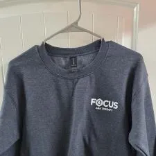 Customer photo from Focus of our Gildan 8 oz. Heavy Blend 50/50 Crew Sweatshirt - Screen, a grey sweatshirt with white text on it