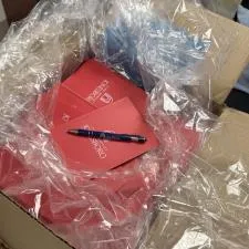 Customer photo from Sharla of our Roslin Incline Stylus Pen, a box with red papers and a pen