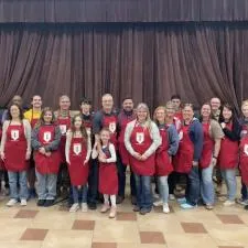 Customer photo from Mike of our Q-Tees Full Length 2 Pocket Apron, a group of people wearing aprons posing for a photo