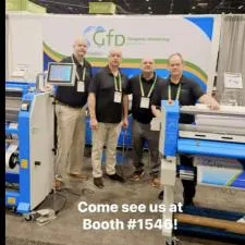 Customer photo from Kelly of our Under Armour Stretch Performance Polo - Men's - Embroidered, a group of men standing in front of a large machine