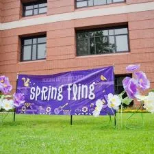 Customer photo from Ashley of our Value Outdoor Banner - 4' x 10', a purple banner with white flowers in front of a building