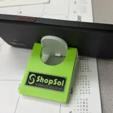 Customer photo from Adam of our Fold Flat Phone Stand with Microfiber Cloth, a cell phone on a calendar